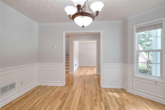 662 Shady Willow Ln, Loganville, GA 30052 - unfurnished dining area featuring a chandelier, light wood-type flooring, a textured ceiling, wainscoting, and stairway