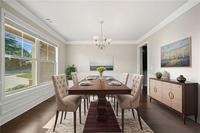 dining space featuring visible vents, dark wood-style flooring, ornamental molding, wainscoting, and a chandelier