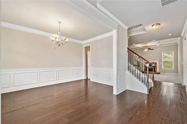 empty room featuring visible vents, dark wood-type flooring, stairs, ornamental molding, and ceiling fan with notable chandelier