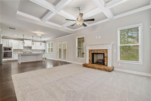 unfurnished living room featuring coffered ceiling, baseboards, and a ceiling fan