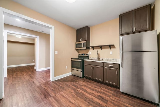 kitchen with light countertops, dark brown cabinets, appliances with stainless steel finishes, and a sink