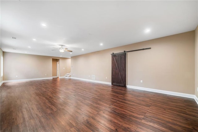 unfurnished room featuring dark wood-style floors, baseboards, recessed lighting, ceiling fan, and a barn door