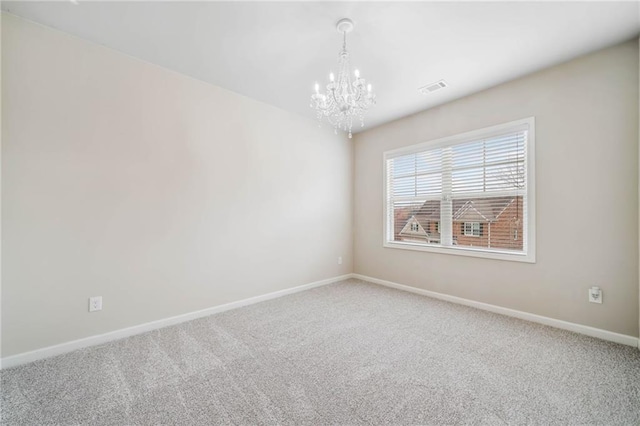 carpeted empty room with visible vents, baseboards, and a notable chandelier