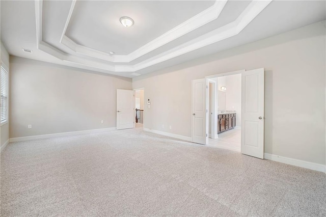 unfurnished room featuring baseboards, a raised ceiling, light colored carpet, and visible vents