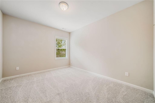 spare room featuring baseboards, carpet floors, and visible vents