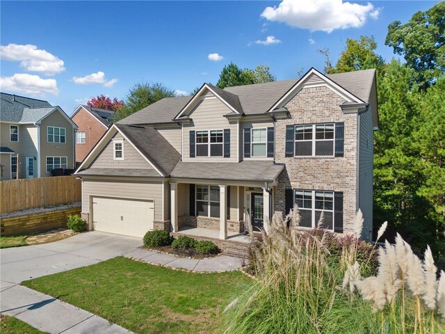 craftsman house featuring fence, covered porch, concrete driveway, a garage, and brick siding