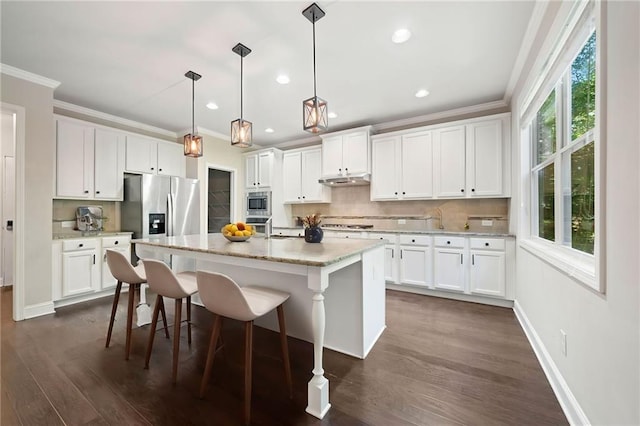 kitchen with tasteful backsplash, appliances with stainless steel finishes, ornamental molding, and dark wood finished floors