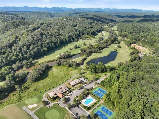 drone / aerial view featuring a water and mountain view and a view of trees