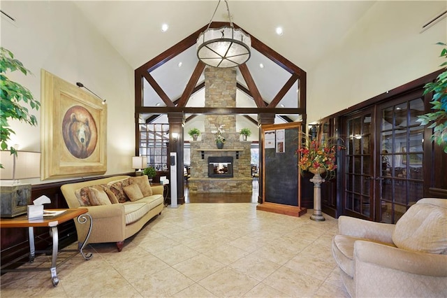 living area with high vaulted ceiling, tile patterned floors, and a stone fireplace