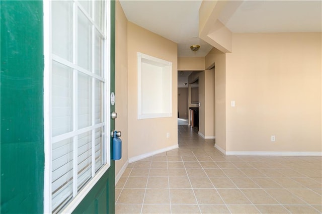 interior space with baseboards and light tile patterned floors