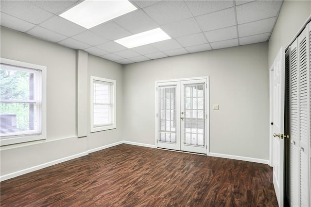 740 Creek Wind Ct, Duluth, GA 30097 - empty room featuring dark wood-style flooring, healthy amount of natural light, french doors, baseboards, and a drop ceiling