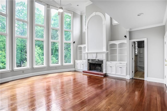 740 Creek Wind Ct, Duluth, GA 30097 - unfurnished living room featuring crown molding, healthy amount of natural light, a ceiling fan, a fireplace, and baseboards