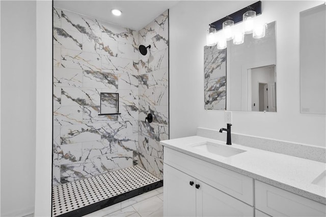 bathroom featuring a tile shower and vanity