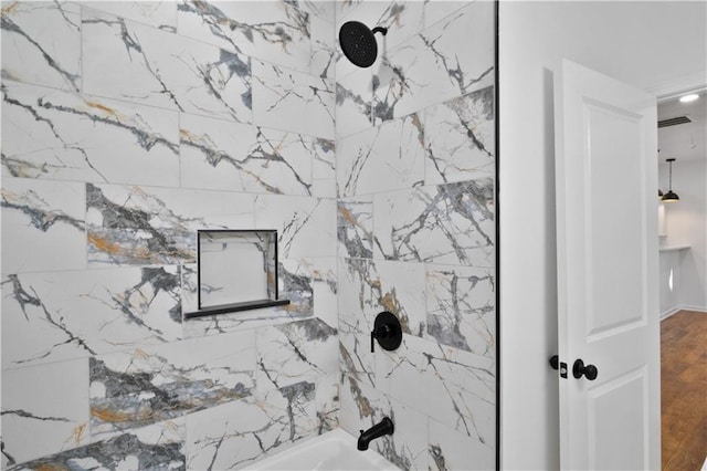 details featuring tiled shower / bath combo and wood-type flooring