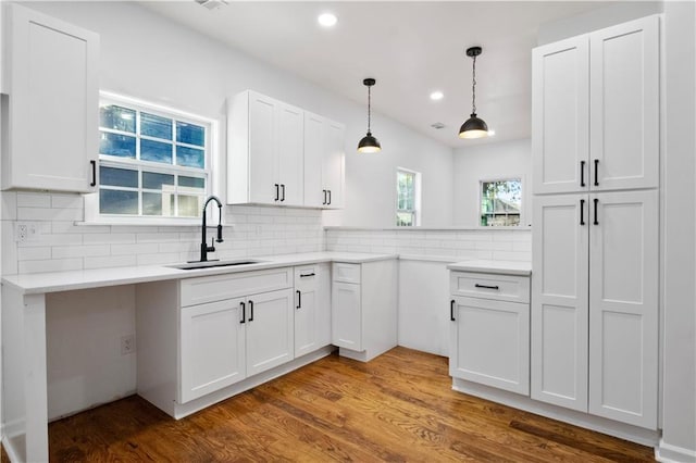 kitchen featuring backsplash, dark hardwood / wood-style floors, white cabinetry, and sink