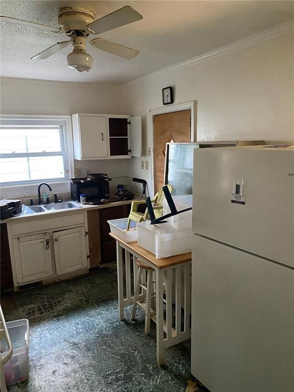 2689 Knox St NE, Atlanta, GA 30317 - kitchen with open shelves, freestanding refrigerator, a ceiling fan, white cabinetry, and a sink