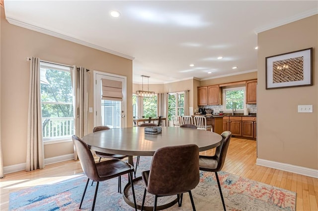 dining space featuring plenty of natural light, crown molding, and light wood-type flooring