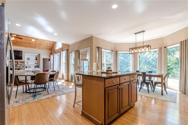 kitchen with light hardwood / wood-style floors, a wealth of natural light, and decorative light fixtures