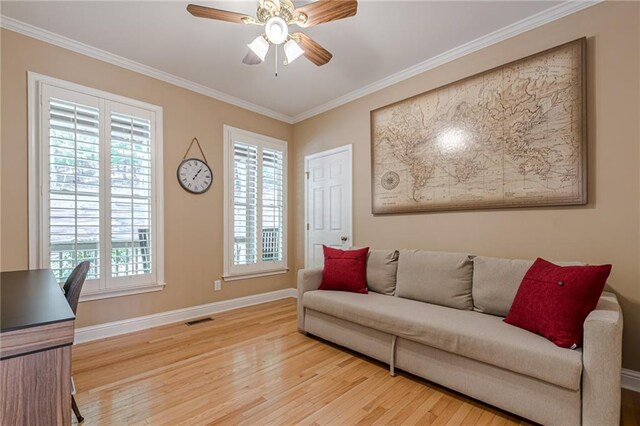 living room featuring light hardwood / wood-style flooring, ceiling fan, and crown molding