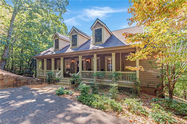 cape cod home featuring a porch