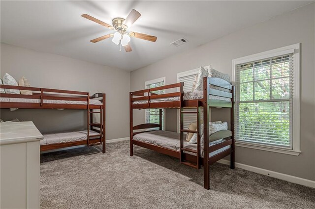 carpeted bedroom with multiple windows and ceiling fan