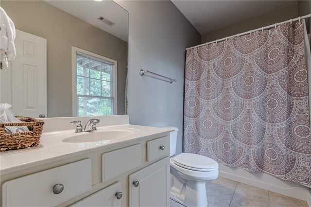 full bathroom with vanity, shower / bath combo, toilet, and tile patterned floors