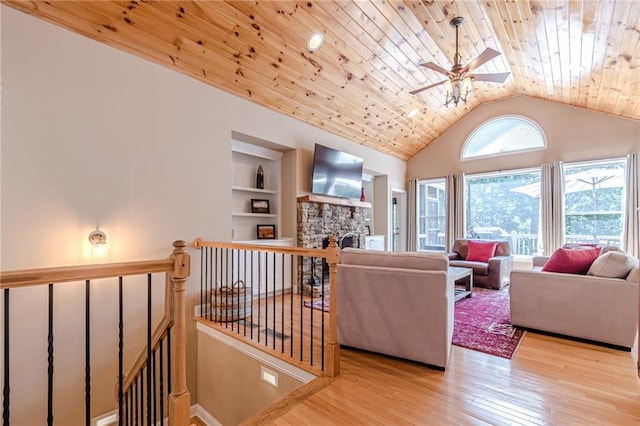 living room with built in features, a fireplace, light hardwood / wood-style floors, and wooden ceiling