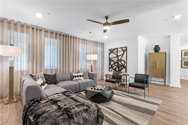 living room with ceiling fan and light hardwood / wood-style flooring