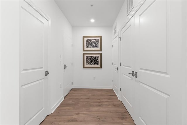 corridor with hardwood / wood-style flooring