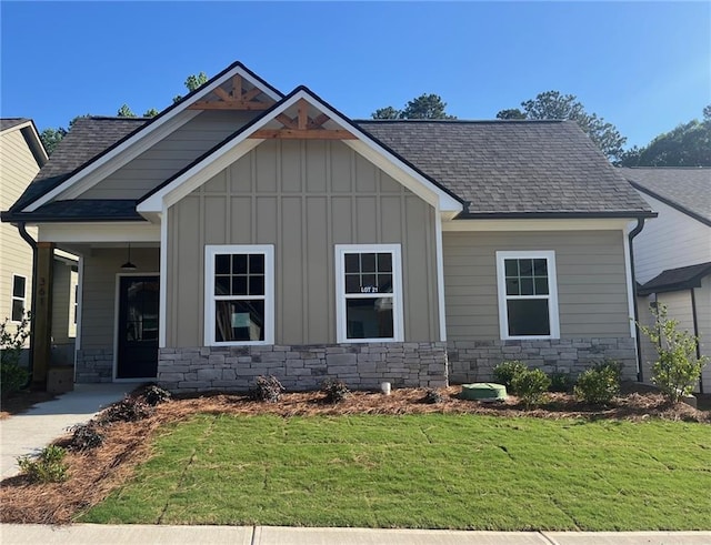 361 Creek Wood Park Dr, Ball Ground, GA 30107 - craftsman-style house featuring board and batten siding, a front yard, roof with shingles, and stone siding