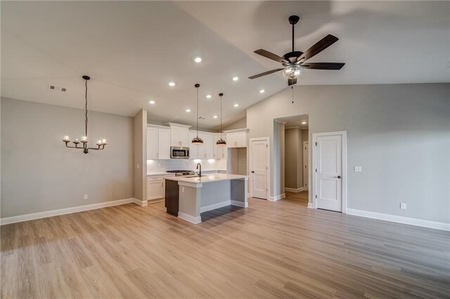361 Creek Wood Park Dr, Ball Ground, GA 30107 - kitchen with stainless steel microwave, open floor plan, a sink, ceiling fan, and a center island with sink