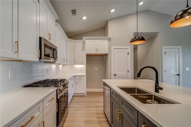 361 Creek Wood Park Dr, Ball Ground, GA 30107 - kitchen featuring stainless steel appliances, a sink, lofted ceiling, white cabinets, and pendant lighting