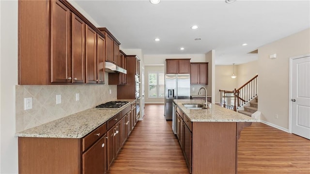 705 Ayala Pl, Alpharetta, GA 30004 - kitchen featuring a breakfast bar, a sink, light wood-style floors, stainless steel appliances, and backsplash