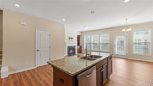 705 Ayala Pl, Alpharetta, GA 30004 - kitchen with stainless steel dishwasher, a fireplace with flush hearth, wood finished floors, open floor plan, and a sink