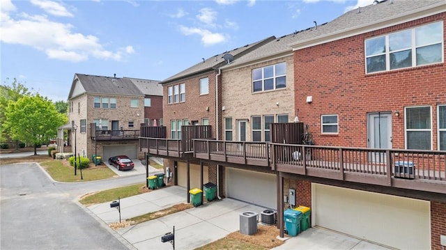 705 Ayala Pl, Alpharetta, GA 30004 - back of house with driveway, a residential view, central AC unit, brick siding, and an attached garage