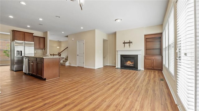 705 Ayala Pl, Alpharetta, GA 30004 - kitchen with light wood-type flooring, a sink, open floor plan, stainless steel appliances, and an island with sink