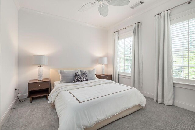 bedroom featuring ceiling fan, ornamental molding, and light carpet