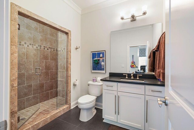 bathroom featuring toilet, walk in shower, tile patterned floors, crown molding, and vanity