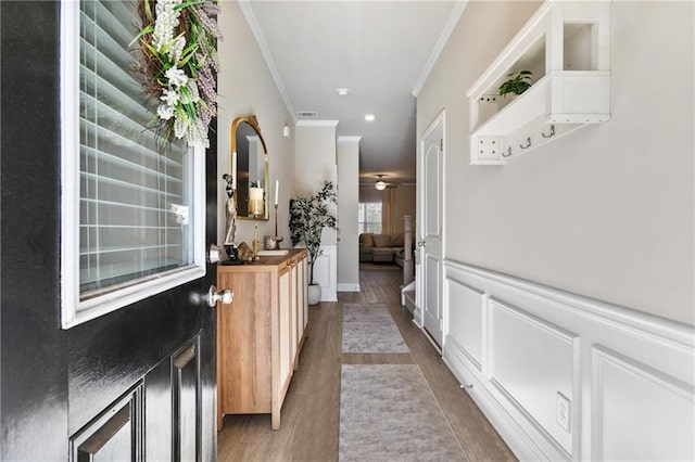 corridor with hardwood / wood-style floors and crown molding