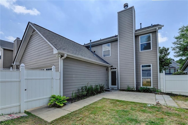 595 Stonepark Ln, Suwanee, GA 30024 - back of house featuring a chimney, a patio, a gate, a garage, and roof with shingles