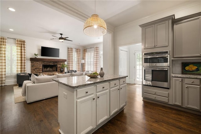 1003 N Ave NE, Atlanta, GA 30306 - kitchen with stainless steel double oven, ornamental molding, a ceiling fan, a stone fireplace, and gray cabinetry