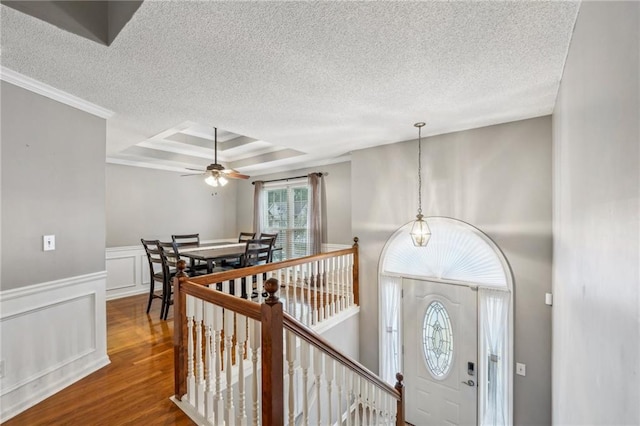 entryway with hardwood / wood-style flooring, ceiling fan, a textured ceiling, and a tray ceiling