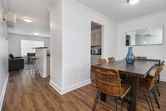 dining space with ornamental molding and dark hardwood / wood-style floors