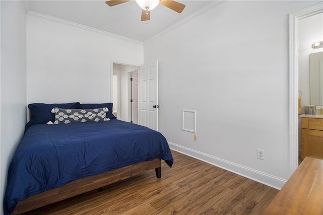 bedroom featuring ensuite bath, wood finished floors, crown molding, baseboards, and ceiling fan