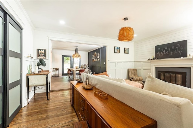 1443 Fama Dr NE, Atlanta, GA 30329 - living area featuring dark wood finished floors, crown molding, a glass covered fireplace, a chandelier, and recessed lighting