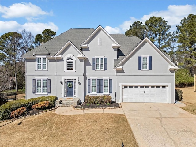 view of front of home featuring concrete driveway, an attached garage, and stucco siding