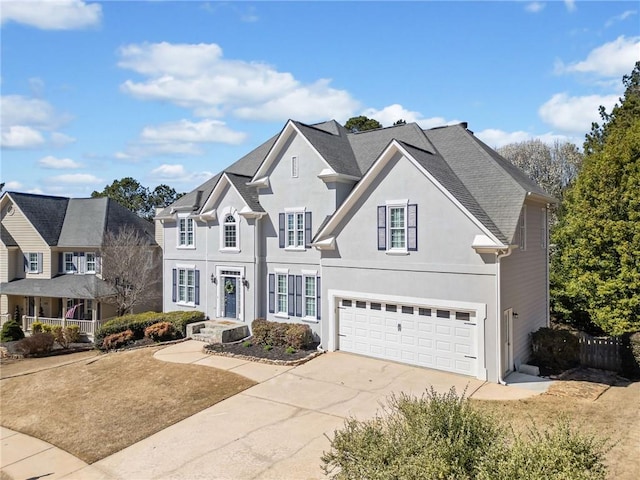 traditional home featuring a garage, concrete driveway, and stucco siding