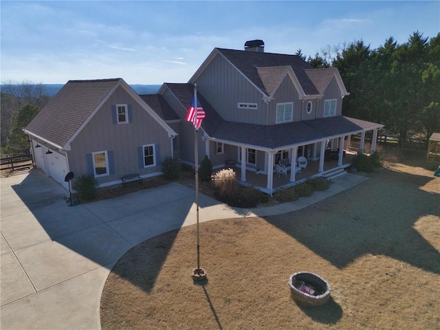 view of front of property with a front yard, a porch, a garage, and an outdoor structure