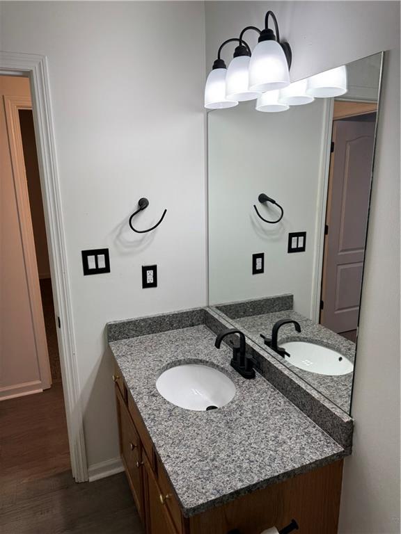 bathroom with vanity, baseboards, and wood finished floors