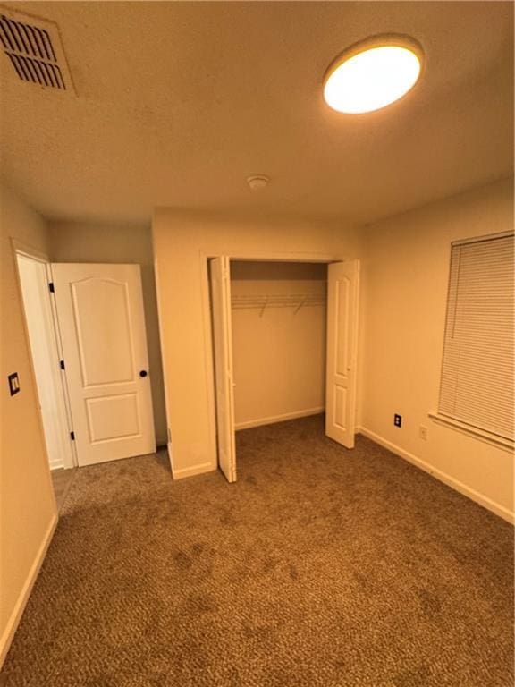 unfurnished bedroom featuring visible vents, baseboards, and dark carpet
